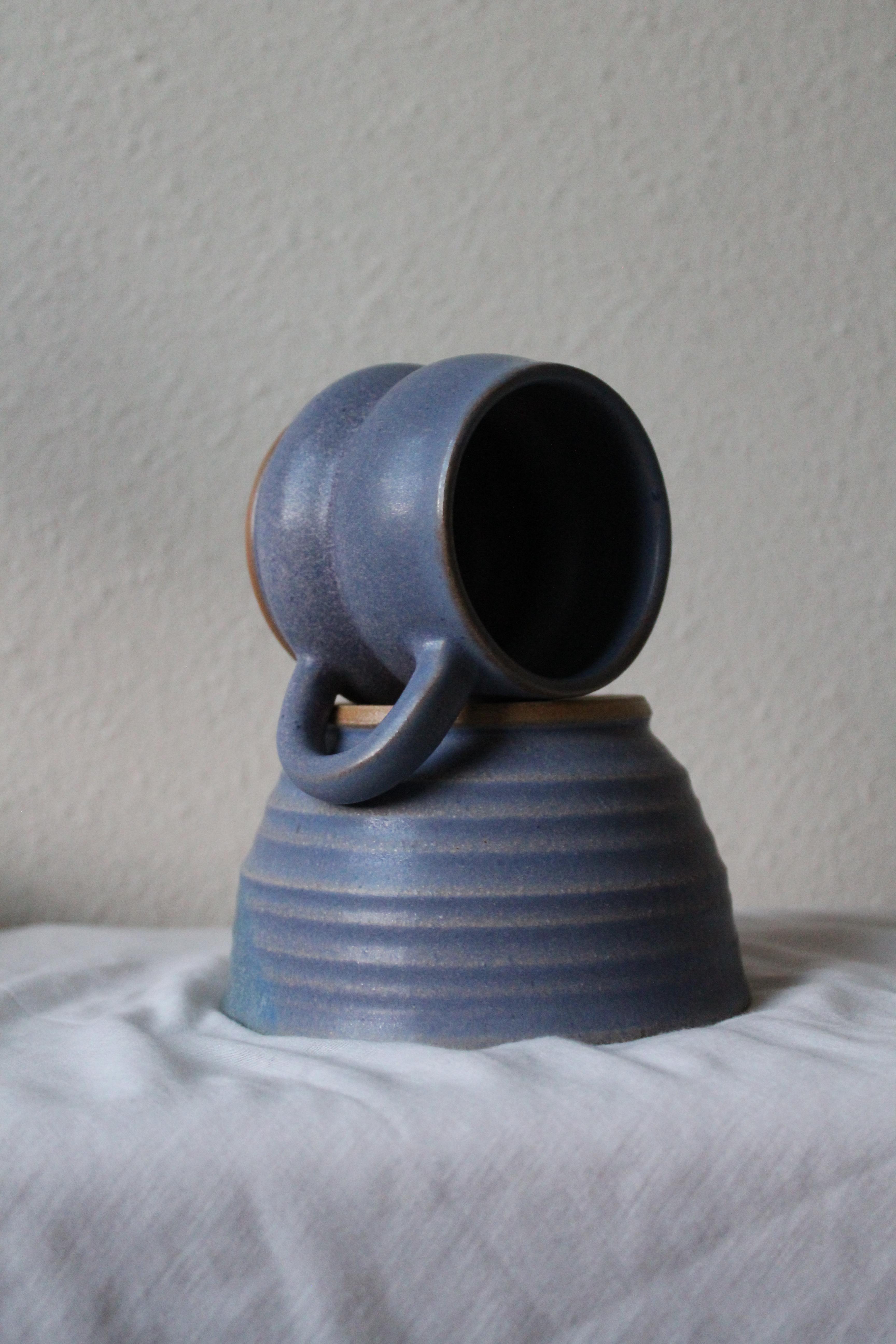 Handcrafted blue ceramic mug with curved handle